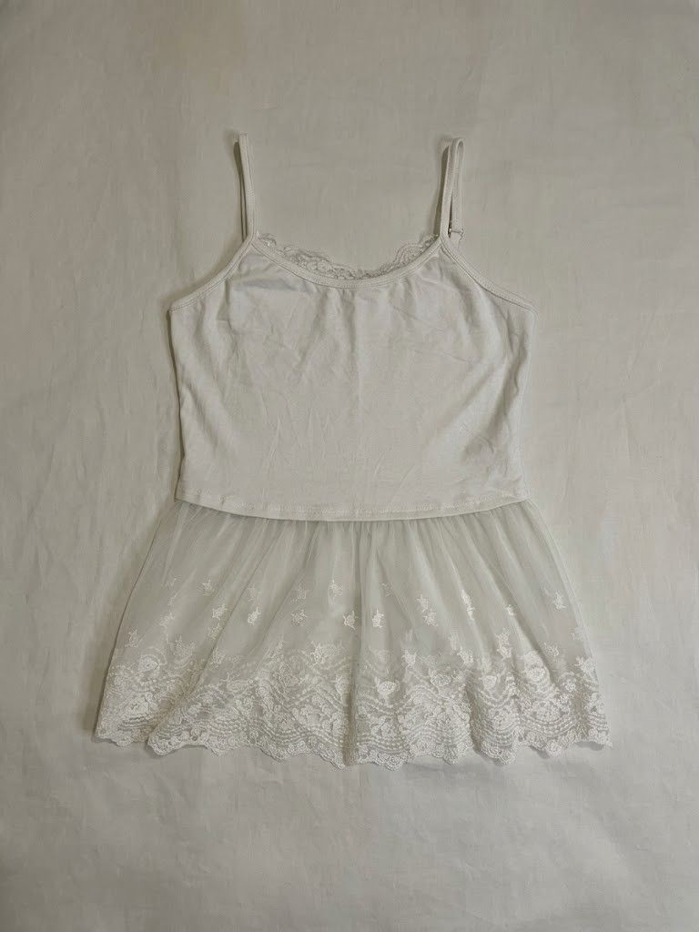 White Lace Cami Top with Mesh Ruffle Hem (Category: Sleeveless) located in Binan City. Submitted by declutterbyjwy (Listing ID 1465714517, Image 1). Description: bust: 32-36" | waist: 24-28 | length: 21" - perf for layering or solo - adjustable strap - cotton fabric - good as new, never used & no stains/flaws ps. last photo is inspo only.