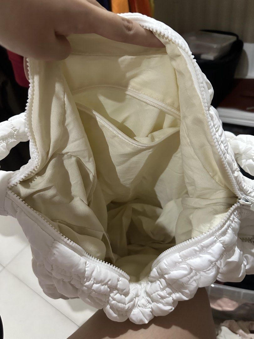 White Puffer Cloud Shoulder Bag Quilted Hobo (Category: Shoulder Bags) located in Quezon City. Submitted by cassie.u (Listing ID 1465639369, Image 3). Description: - Color & Style: White quilted puffer bag with a soft cloud texture and neutral match-all design - Closure: Secure zip top closure - Storage: Includes 2 handy inner zippered pockets for small essentials - Strap: Thick, comfortable ruched shoulder strap - Material: Lightweight and ideal