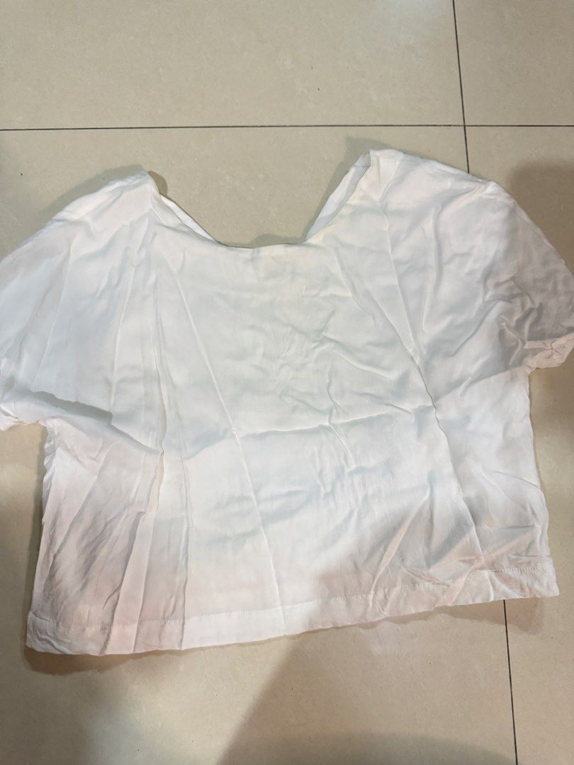White Short Sleeve V-Neck Crop Top (Category: Shirts) located in Quezon City. Submitted by sweetlyluxe (Listing ID 1465625112, Image 3). Description: - fits up to M - Color: Plain White - Style: V-neck crop top with short sleeves - Lining: Features a layered inner lining for extra coverage - Fabric: Lightweight and breezy - Pairing: Perfect with high-waisted jeans or skirts - Condition: Clean and ready to wear.