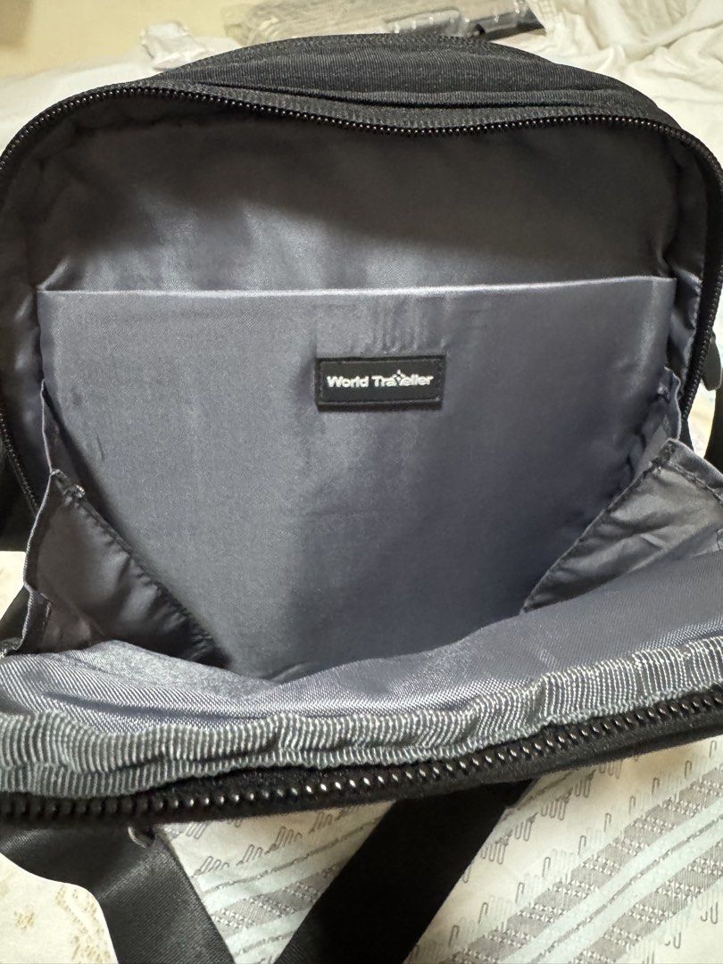 World Traveller Sling Bag Fits Ipad (Category: Sling Bags) located in Manila. Submitted by micbri (Listing ID 1465723454, Image 3). Description: World Traveller Crossbody/ Sling Bag - Color: Classic black - Material: Durable, high-quality fabric - Compartments: Multiple zippered compartments for secure storage - Interior: Stylish grey lining with organizational pockets and branded patch - Exterior: Convenient front zip pocket and rear slip pocket