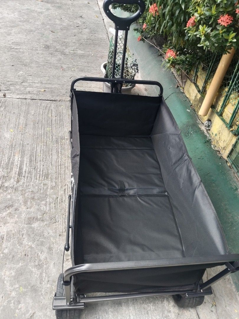 Wthb Outdoor Folding Utility Wagon Black (Category: Hiking & Camping) located in Cavite. Submitted by ambersaints (Listing ID 1465625526, Image 3). Description: - Brand: Wthb Outdoor - Color: Sleek All-Black - Frame: Sturdy metal with heavy-duty fabric - Mobility: Large wheels designed for grass, dirt, and pavement - Handle: Ergonomic loop grip for easy pulling - Storage: Folds completely flat to fit car trunks and tight spaces - Best for: Campin