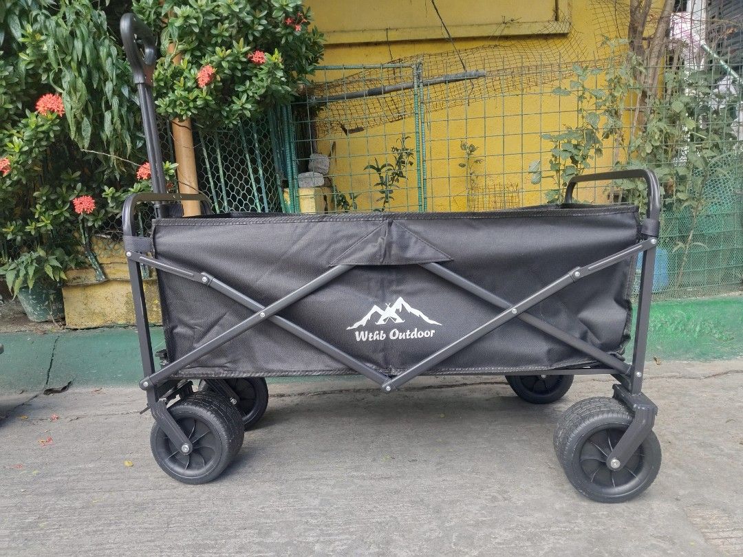 Wthb Outdoor Folding Utility Wagon Black (Category: Hiking & Camping) located in Cavite. Submitted by ambersaints (Listing ID 1465625526, Image 2). Description: - Brand: Wthb Outdoor - Color: Sleek All-Black - Frame: Sturdy metal with heavy-duty fabric - Mobility: Large wheels designed for grass, dirt, and pavement - Handle: Ergonomic loop grip for easy pulling - Storage: Folds completely flat to fit car trunks and tight spaces - Best for: Campin