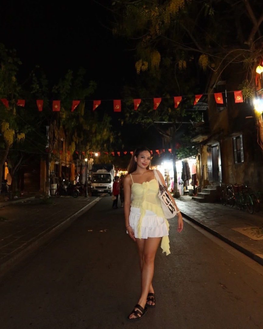 Yellow Asymmetric Ruffle Camisole Top (Category: Sleeveless) located in Cavite. Submitted by mcjkim (Listing ID 1465703156, Image 3). Description: - Brand: Klalien - Color: Vibrant yellow - Style: Spaghetti strap camisole with an asymmetric cascading ruffle hem - Detail: Charming fabric rose accent on the front bodice - Material: Lightweight and breezy, ideal for summer outings or night walks - Condition: Worn only once in Hoi An, Vietnam.