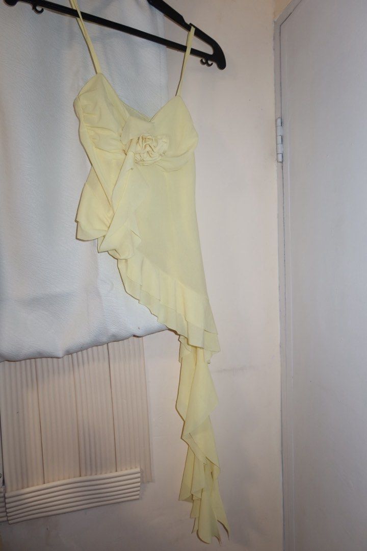 Yellow Asymmetric Ruffle Camisole Top (Category: Sleeveless) located in Cavite. Submitted by mcjkim (Listing ID 1465703156, Image 1). Description: - Brand: Klalien - Color: Vibrant yellow - Style: Spaghetti strap camisole with an asymmetric cascading ruffle hem - Detail: Charming fabric rose accent on the front bodice - Material: Lightweight and breezy, ideal for summer outings or night walks - Condition: Worn only once in Hoi An, Vietnam.