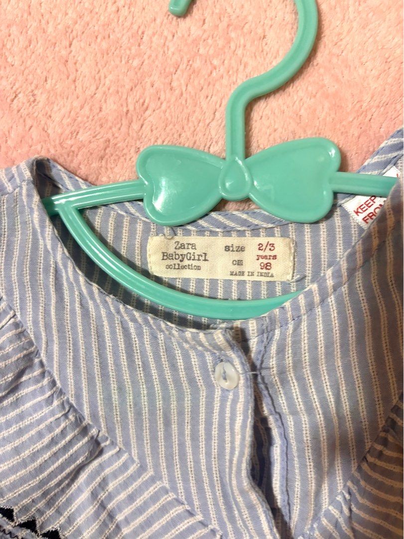 Zara Baby light blue and white vertical striped button-front blouse (Category: Babies & Kids Fashion) located in Quezon City. Submitted by closettreasure123 (Listing ID 1465597656, Image 2). Description: featuring a distinctive layered v-shaped ruffle collar with black geometric embroidered trim..