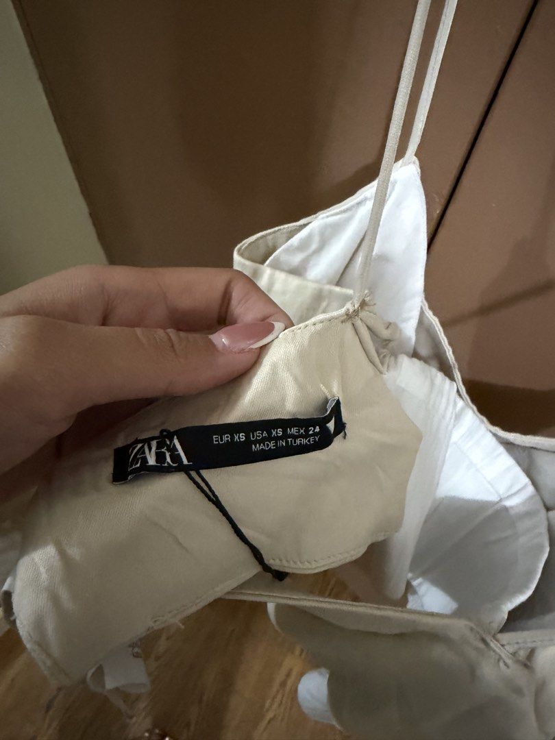 Zara Beige Spaghetti Strap Crop Top Size XS (Category: Sleeveless) located in Quezon City. Submitted by declutterbycy (Listing ID 1465758847, Image 2). Description: - Brand: Zara - Size: XS (Made in Turkey) - Color: Beige with a layered white hem - Details: Thin spaghetti straps, lightweight fabric - Condition: Clean and well-maintained - Styling: Perfect to match with high-waisted shorts or skirts.
