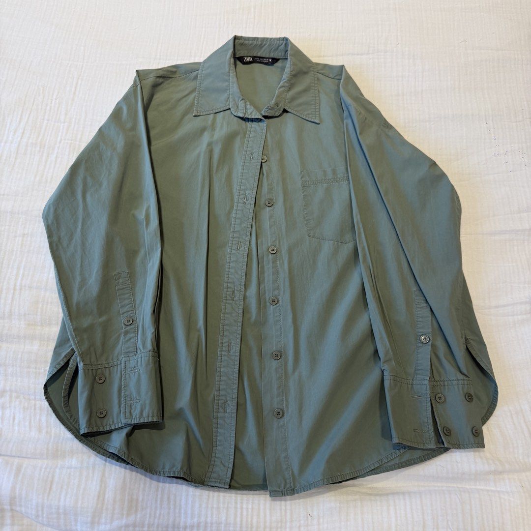 Zara Green Long Sleeve Button-Down Shirt Size S (Category: Longsleeves) located in Manila. Submitted by vea1992 (Listing ID 1465655856, Image 1). Description: - Brand: Zara - Size: S - Color: Neutral khaki-sage green - Origin: Made in Morocco - Features: Single chest pocket, wide button cuffs, pleated back yoke, and rounded hem - Styling: Versatile piece, great for layering or solo wear.
