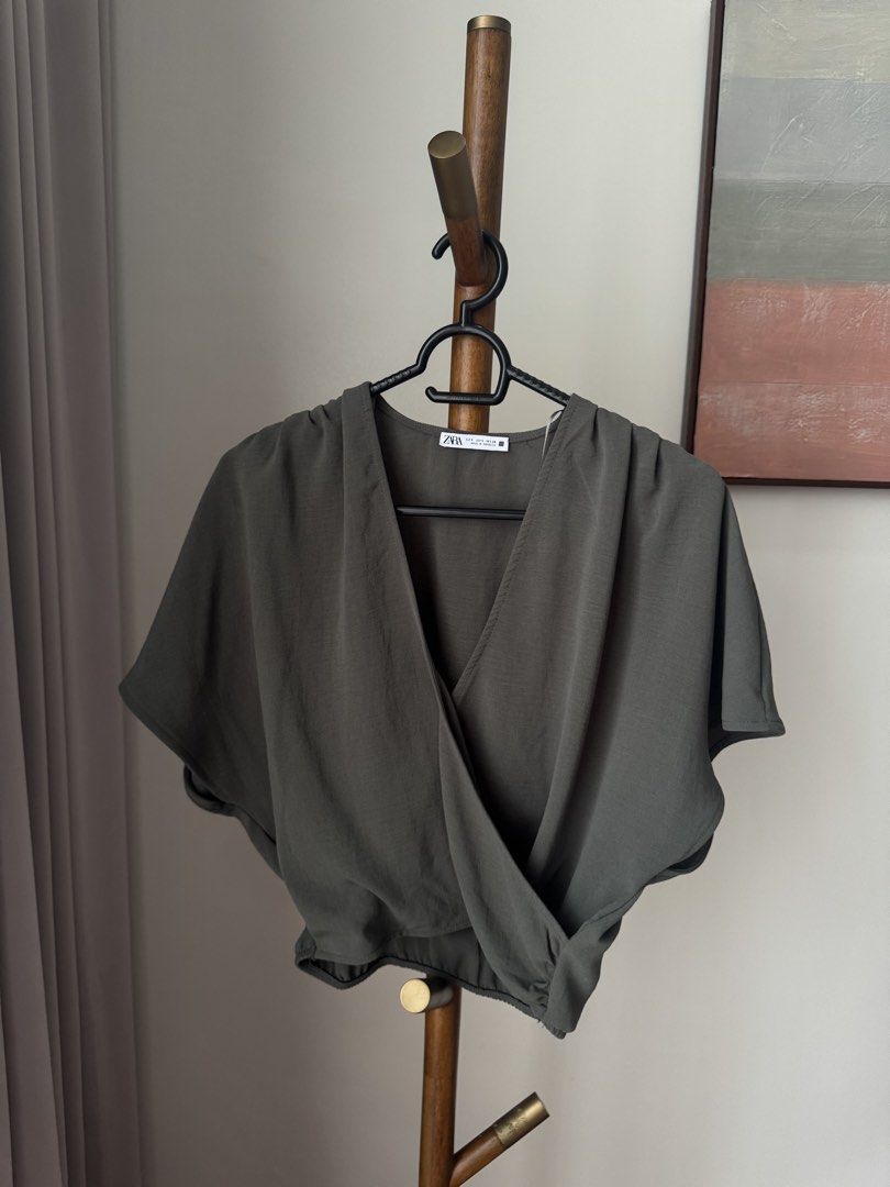 Zara Olive Green Wrap Blouse (Category: Blouses) located in Pasig City. Submitted by kutleyn (Listing ID 1465657556, Image 1). Description: - Brand: Zara - Size: S - Color: Dark Olive Green - Material: Lightweight textured fabric (Made in Morocco) - Design: Deep V-neck, crossover front, short kimono sleeves, and elasticated waist - Condition: Great wardrobe staple, easy to dress up or down.