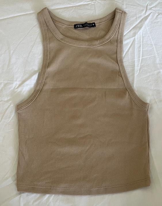 Zara Ribbed Tank Top Beige (Category: Sleeveless) located in Las Pinas. Submitted by francesaly (Listing ID 1465674576, Image 1). Description: - Brand: Zara - Color: Beige - Style: High neckline, racerback cut - Material: Stretchy and super comfortable fabric - Versatility: Perfect for daily wear, layering under cardigans, or wearing solo in warm weather.