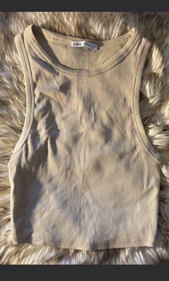 Zara Ribbed Tank Top Beige (Category: Sleeveless) located in Las Pinas. Submitted by francesaly (Listing ID 1465674576, Image 2). Description: - Brand: Zara - Color: Beige - Style: High neckline, racerback cut - Material: Stretchy and super comfortable fabric - Versatility: Perfect for daily wear, layering under cardigans, or wearing solo in warm weather.