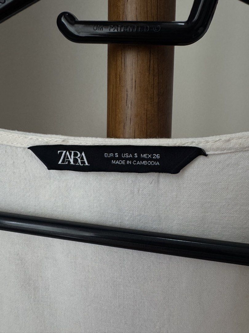 Zara White Button-Front Blouse Size S (Category: Blouses) located in Pasig City. Submitted by kutleyn (Listing ID 1465653873, Image 2). Description: - Brand: Zara - Size: S - Color: White - Design: Square neckline with button-front closure - Sleeves: Short flared sleeves - Fit: Cropped length with subtle ruffled hem - Origin: Made in Cambodia.