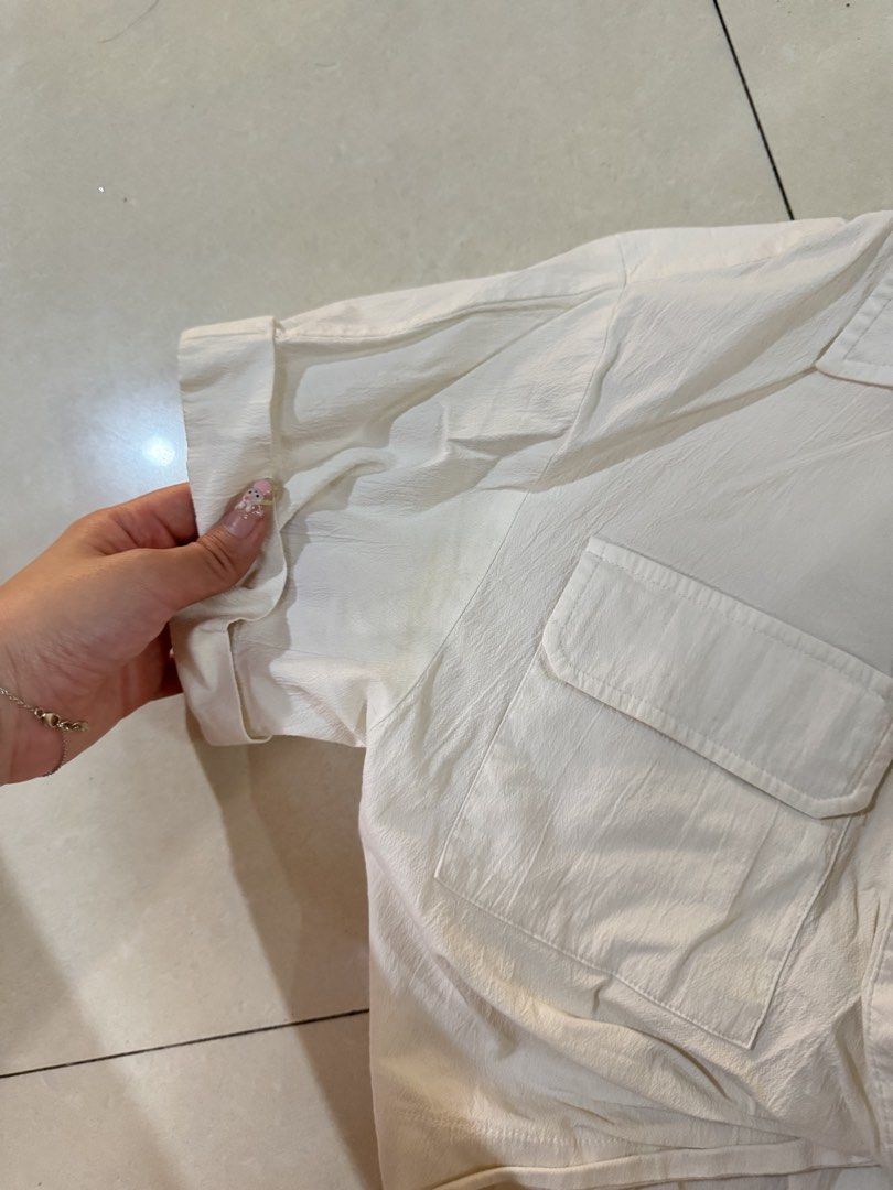 ZARA White Crop Shirt Size (Category: Shirts) located in Quezon City. Submitted by sweetlyluxe (Listing ID 1465623158, Image 2). Description: - Brand: Zara - Size: EUR XS / USA XS / MEX 24 - Color: White - Material: Lightweight textured fabric (Made in Turkey) - Details: Short cuffed sleeves, classic collar, dual chest pockets, and front tie-knot hem - Styling: Great to pair with high-waisted denim or skirts - Condition: yellowish on some parts, 