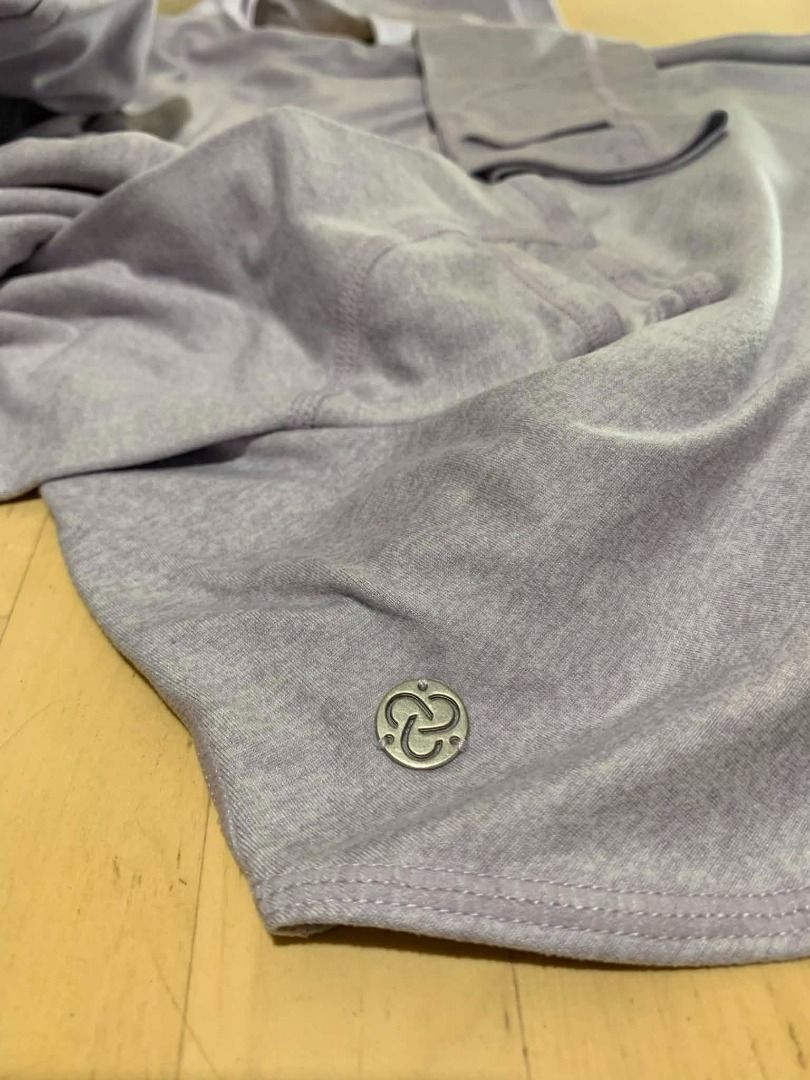 Zella Lavender Heathered Pullover Hoodie Sweatshirt Size Small (Category: Coats, Jackets and Outerwear) located in Manila. Submitted by musedeclutters (Listing ID 1465643386, Image 3). Description: - Brand: Zella - Size: Small (S) - Color: Soft lavender heather - Material/Interior: Cozy fleece texture - Design: Crossover collar, adjustable drawstring hood, long sleeves - Features: Front kangaroo pocket, curved hem, small metallic logo charm - Con