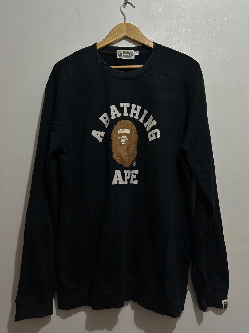 A Bathing Ape BAPE Arch Logo Black Sweatshirt (Category: Coats, Jackets and Outerwear) located in Calbayog City. Submitted by thrift.bucks101 (Listing ID 1471236713, Image 1). Description: - Brand: A Bathing Ape (BAPE) by Nowhere Co., Ltd. - Color: Black - Size: XXL - Material: 100% premium cotton - Design: Large chenille ape head graphic with printed arch lettering - Details: Classic ape head sleeve tag on left cuff - Condition: Clean, worn a fe