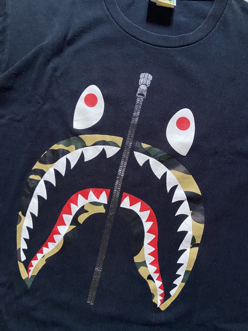 A Bathing Ape (BAPE) Black Camo Shark Tee (Category: Tshirts & Polo Shirts ) located in Cotabato. Submitted by haikal.kasim (Listing ID 1471159431, Image 3). Description: A Bathing Ape (BAPE) Black Camo Shark Tee Size: Large Dimes: W21*L27.5 Excellent Condition Color rate: 9.4/10 No issue Washed and ready to use.