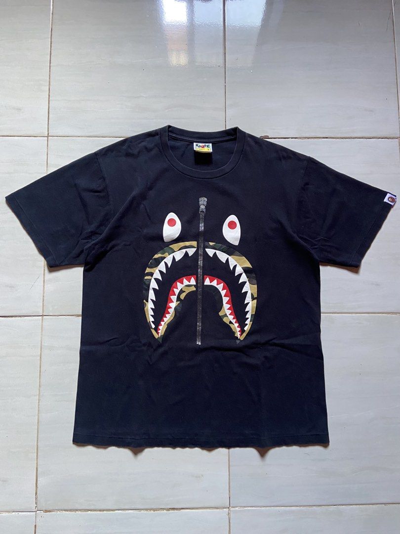 A Bathing Ape (BAPE) Black Camo Shark Tee (Category: Tshirts & Polo Shirts ) located in Cotabato. Submitted by haikal.kasim (Listing ID 1471159431, Image 1). Description: A Bathing Ape (BAPE) Black Camo Shark Tee Size: Large Dimes: W21*L27.5 Excellent Condition Color rate: 9.4/10 No issue Washed and ready to use.