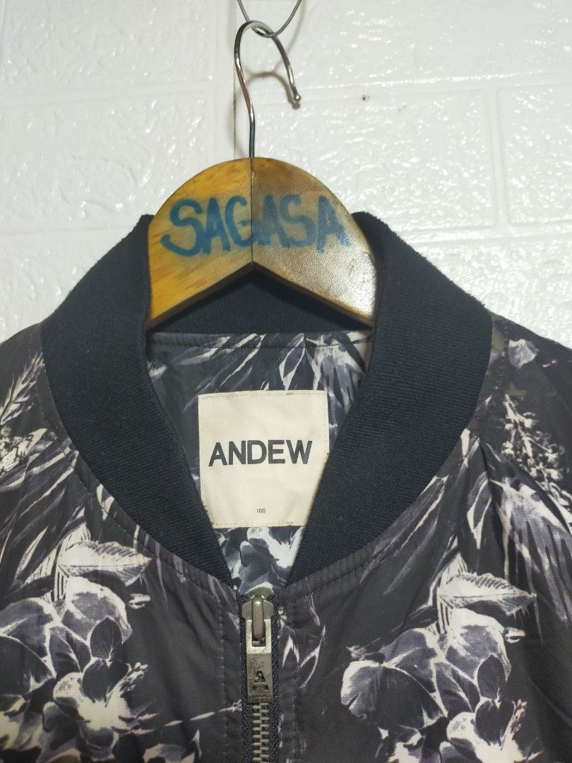 Andew Black Floral Print Bomber Jacket Size 100 (Category: Coats, Jackets and Outerwear) located in Valencia. Submitted by cabisaythriftshop (Listing ID 1471222603, Image 2). Description: - Brand: Andew - Design: Striking black and white floral leaf pattern - Size: Tagged 100 (Regular Fit) - Material/Style: Lightweight bomber jacket with ribbed black collar, cuffs, and hem - Features: Full front zip closure and an extra utility zip pocket on the 