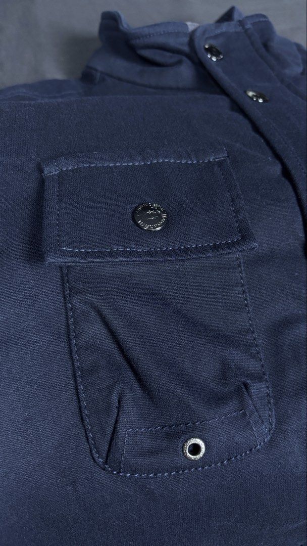 Ashworth Full-Zip With Buttons Vest (Category: Vests) located in Bacoor. Submitted by calvinmanzano13 (Listing ID 1471221806, Image 3). Description: - L = 25.5” | W = 21” - Color: Navy Blue - Warm quilted inner lining - Multiple front flap pockets with metal snap buttons - Extra chest zipper compartment and D-ring detail - Full zip closure with snap button placket - Stand-up collar - Clean fabric and hardware, great for layering Notes: 🔥 Hand wa
