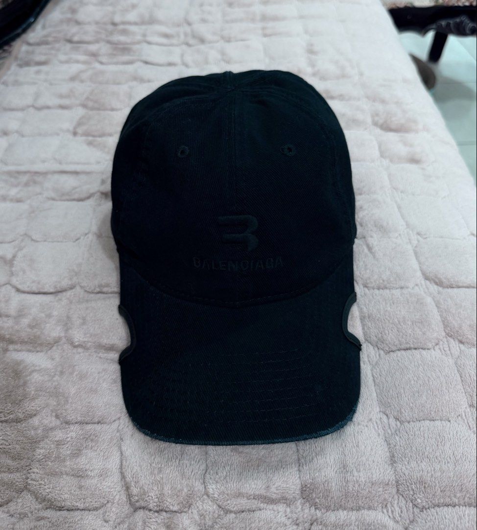 Balenciaga Black Distressed B Logo Baseball Cap (Category: Caps & Hats) located in Imus. Submitted by eacaps (Listing ID 1471149801, Image 1). Description: Black Balenciaga baseball cap featuring a tonal B logo with BALENCIAGA embroidery on the front. Designed with intentional distressed detailing, a curved brim, and an adjustable back strap for a worn-in aesthetic. Details: Brand: Balenciaga Color: Black Style: Baseball Cap Logo: Tonal B Logo De