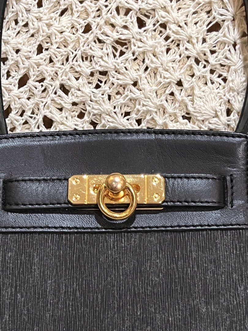 Biodroga Black Handbag with Gold Hardware (Category: Luxury Bags & Wallets) located in Bacolod City. Submitted by vintage_vogue6100 (Listing ID 1471286119, Image 2). Description: - Color: Classic black - Material: Textured fabric body with smooth leather top flap - Hardware: Elegant gold-tone front closure - Strap: Single leather strap - Accent: Includes a branded 'Biodroga' leather tag - Condition: Clean inside and out, neat structure with a sli