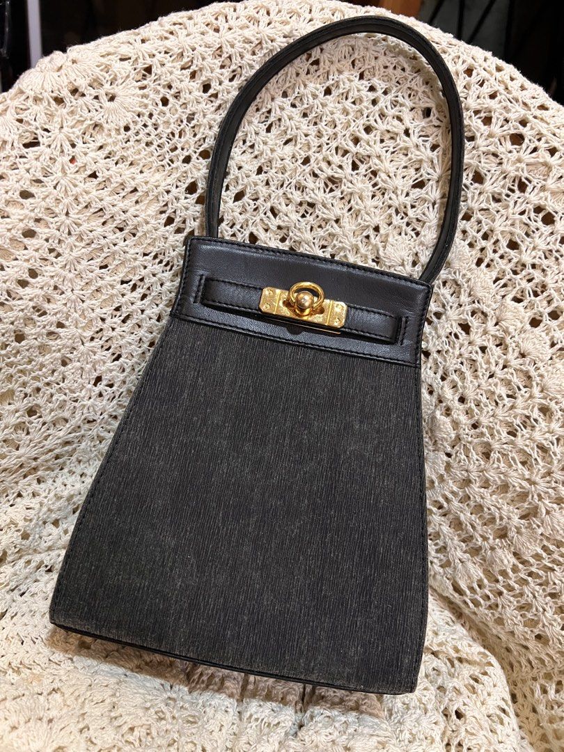 Biodroga Black Handbag with Gold Hardware (Category: Luxury Bags & Wallets) located in Bacolod City. Submitted by vintage_vogue6100 (Listing ID 1471286119, Image 1). Description: - Color: Classic black - Material: Textured fabric body with smooth leather top flap - Hardware: Elegant gold-tone front closure - Strap: Single leather strap - Accent: Includes a branded 'Biodroga' leather tag - Condition: Clean inside and out, neat structure with a sli