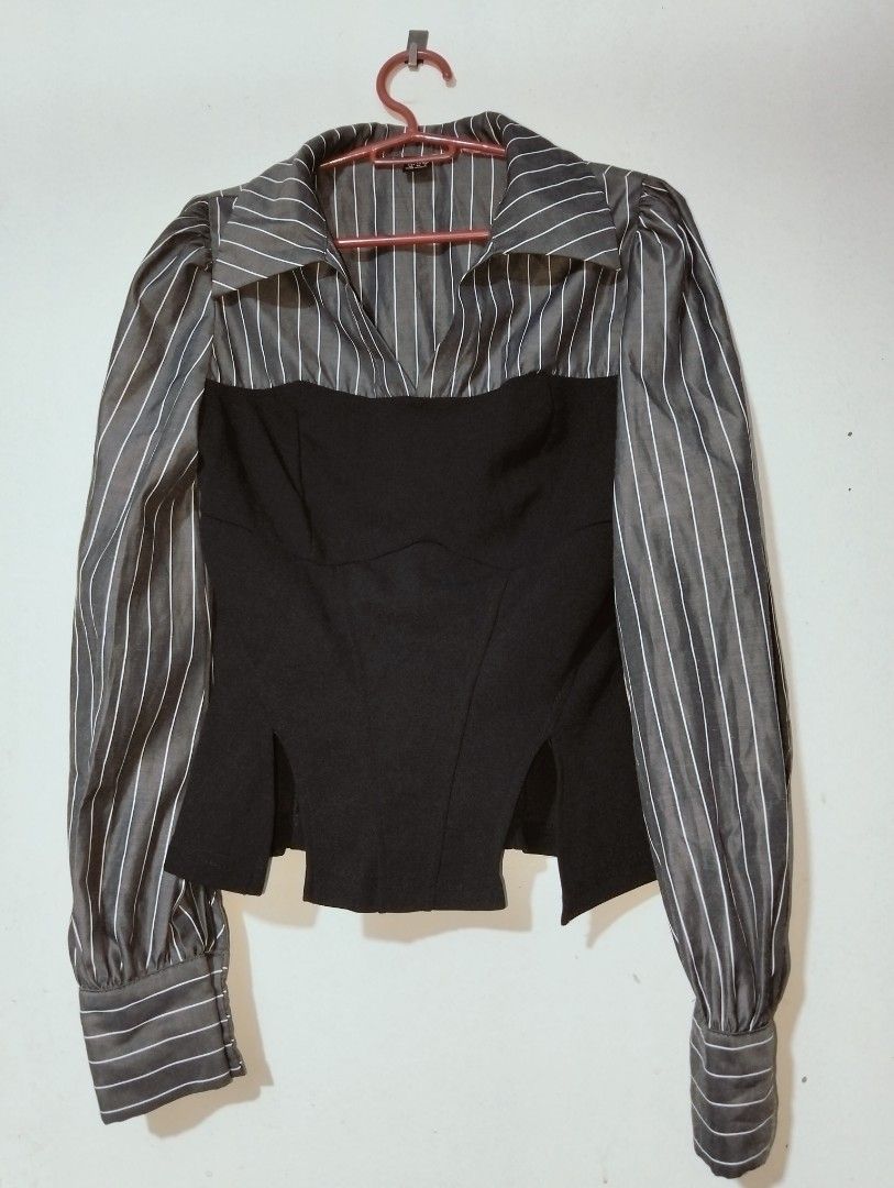 Black and Grey Striped Corset Style Blouse (Category: Blouses) located in Cavite. Submitted by stylewithnics (Listing ID 1471287516, Image 1). Description: Grey and white pinstripe top with a black corset panel overlay. Long sleeves with structured button cuffs. Pointed collar neckline with a deep V-cut. Fitted silhouette with split hem details at the front. Unique hybrid design mixing businesswear and evening styles. Material has a slight sheen.