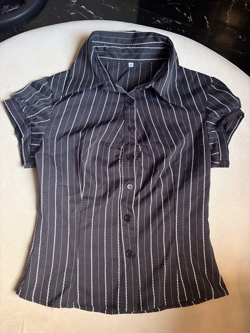 Black and White Pinstripe Short Sleeve Fitted Button Up Blouse (Category: Blouses) located in Makati City. Submitted by savannahsison (Listing ID 1471132425, Image 2). Description: - Color & Pattern: Black with white pinstripes - Style: Classic collared neckline with front button closure - Fit & Details: Fitted silhouette with short puff sleeves - Size: Small (S) - Condition: Lightweight, structured fabric, clean and ready to wear.