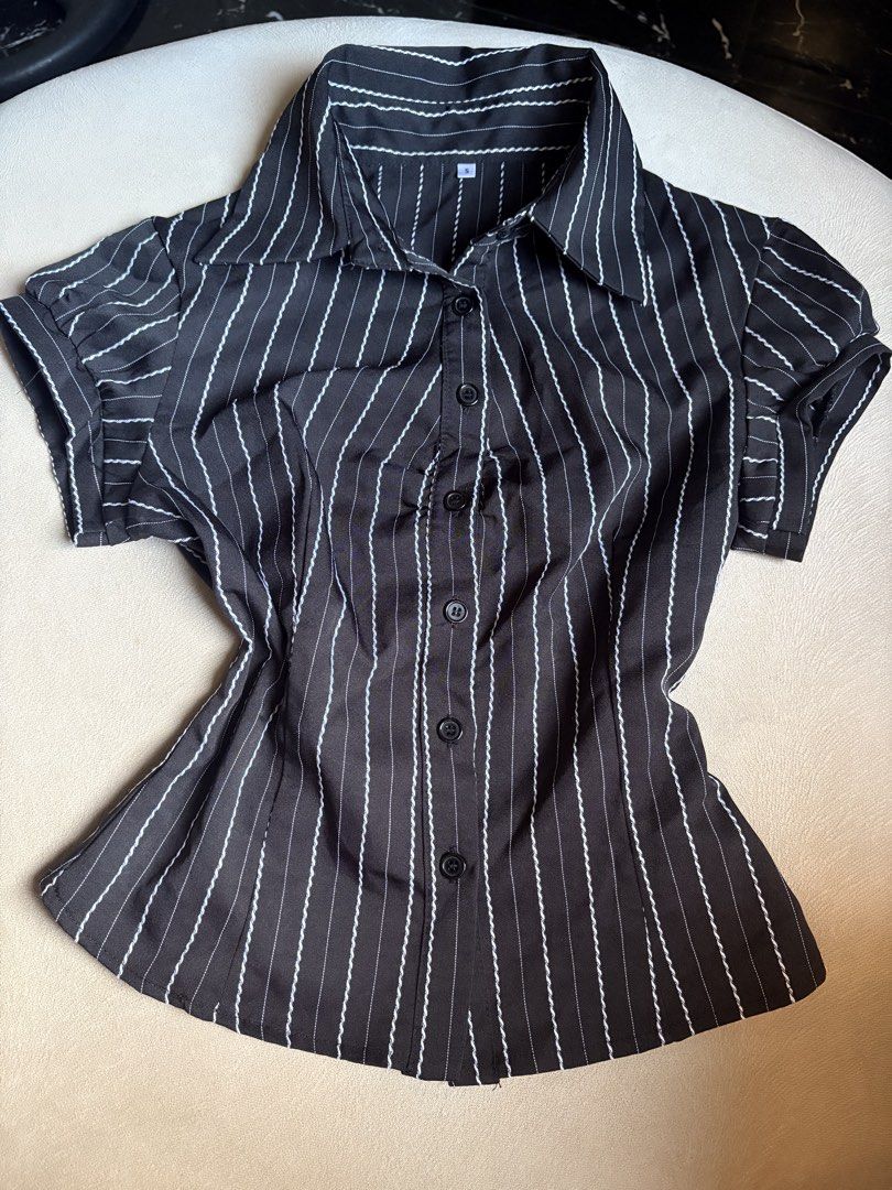 Black and White Pinstripe Short Sleeve Fitted Button Up Blouse (Category: Blouses) located in Makati City. Submitted by savannahsison (Listing ID 1471132425, Image 1). Description: - Color & Pattern: Black with white pinstripes - Style: Classic collared neckline with front button closure - Fit & Details: Fitted silhouette with short puff sleeves - Size: Small (S) - Condition: Lightweight, structured fabric, clean and ready to wear.
