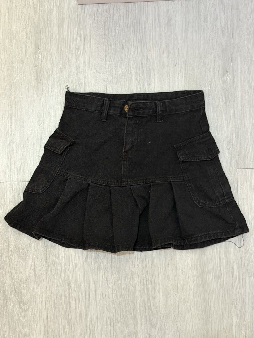 Black Denim Cargo Pleated Skirt (Category: Skirts) located in Manila. Submitted by prelovedbychellyy (Listing ID 1471175371, Image 1). Description: - Style: Y2K street style, flared hem - Design: Pleated with functional utility pockets on both sides - Details: Mid-rise waistband, belt loops, front button fastening - Material: Comfortable cotton denim - Condition: Excellent, no flaws or stains, clean inside and out.