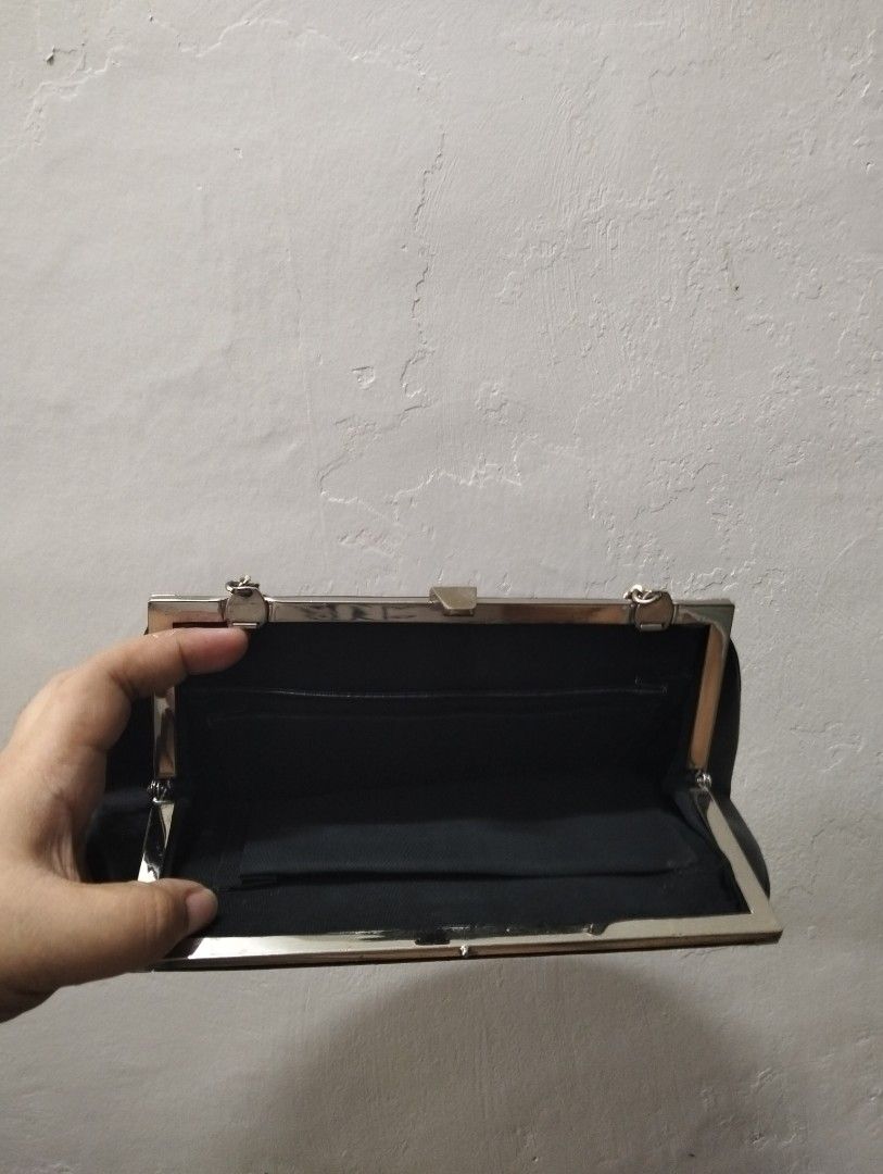 Black leather clutch purse with chain strap (Category: Clutches) located in Gasan. Submitted by AngeliqueKaye (Listing ID 1471209060, Image 2). Description: - Elegant black leather handbag with a secure silver frame closure - Versatile design includes a chain strap that can be tucked in to use as a clutch - Fabric-lined interior complete with a convenient small side pocket - Timeless and classic style, ideal for dinner dates, weddings, and night 