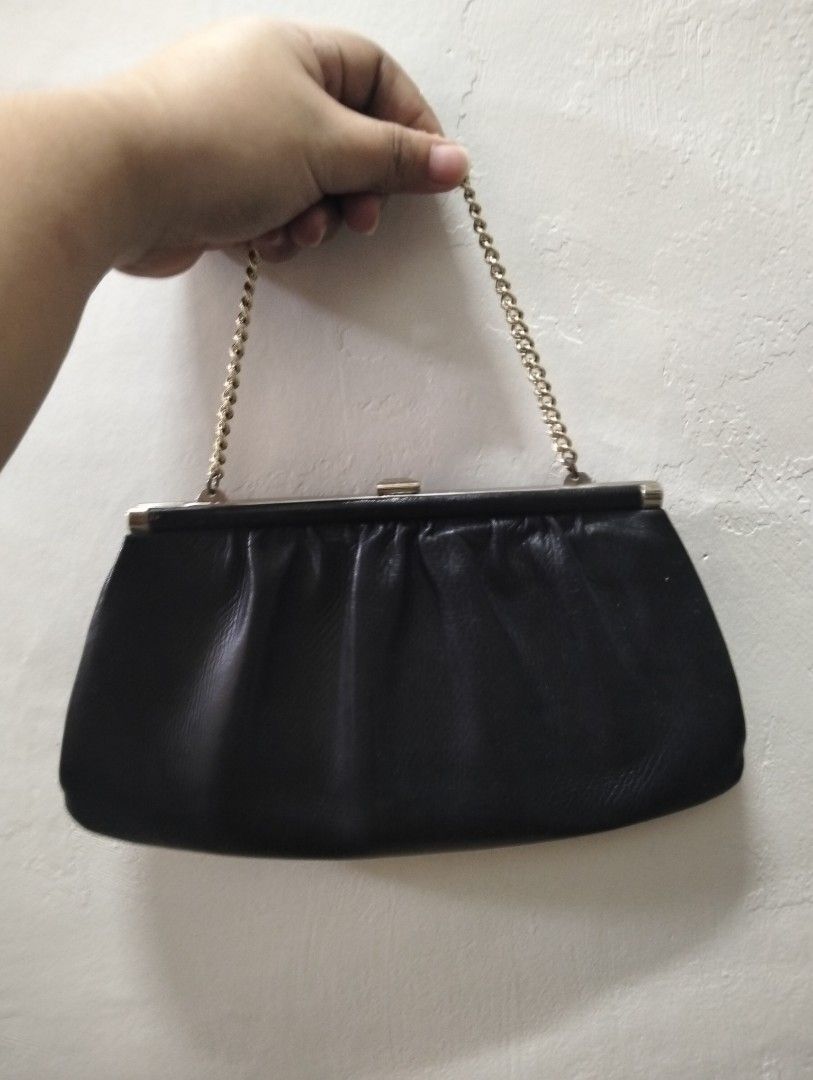Black leather clutch purse with chain strap (Category: Clutches) located in Gasan. Submitted by AngeliqueKaye (Listing ID 1471209060, Image 1). Description: - Elegant black leather handbag with a secure silver frame closure - Versatile design includes a chain strap that can be tucked in to use as a clutch - Fabric-lined interior complete with a convenient small side pocket - Timeless and classic style, ideal for dinner dates, weddings, and night 