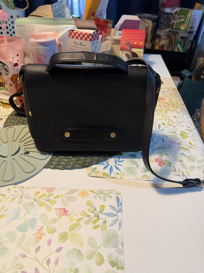 Black Leather Crossbody Bag with Top Handle (Category: Cross-body Bags) located in Manila. Submitted by fitandshop (Listing ID 1471262920, Image 1). Description: - Color & Material: Classic black leather with clean stitching - Design: Structured shape with a chic top handle and secure flap closure - Hardware: Stylish metallic details on the front panel - Versatility: Includes an adjustable shoulder strap for crossbody wear - Size & Use: Compact s