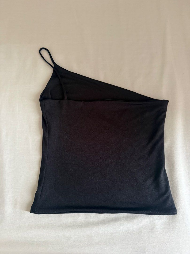 Black One-Shoulder Asymmetrical Strap Tank Top (Category: Sleeveless) located in Quezon City. Submitted by sophiadevegaa (Listing ID 1471143520, Image 1). Description: - Color: Sleek black - Design: Asymmetrical one-shoulder cut with a single thin spaghetti strap and clean angled neckline - Fit: Smooth fabric with a slight stretch for comfort - Styling: Easily pairs with jeans or skirts for a stylish night out look - Vibe: Classic, minimal, and v