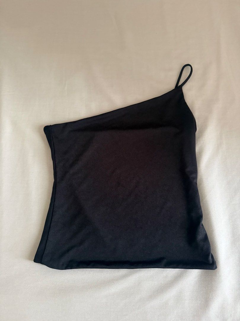 Black One-Shoulder Asymmetrical Strap Tank Top (Category: Sleeveless) located in Quezon City. Submitted by sophiadevegaa (Listing ID 1471143520, Image 2). Description: - Color: Sleek black - Design: Asymmetrical one-shoulder cut with a single thin spaghetti strap and clean angled neckline - Fit: Smooth fabric with a slight stretch for comfort - Styling: Easily pairs with jeans or skirts for a stylish night out look - Vibe: Classic, minimal, and v