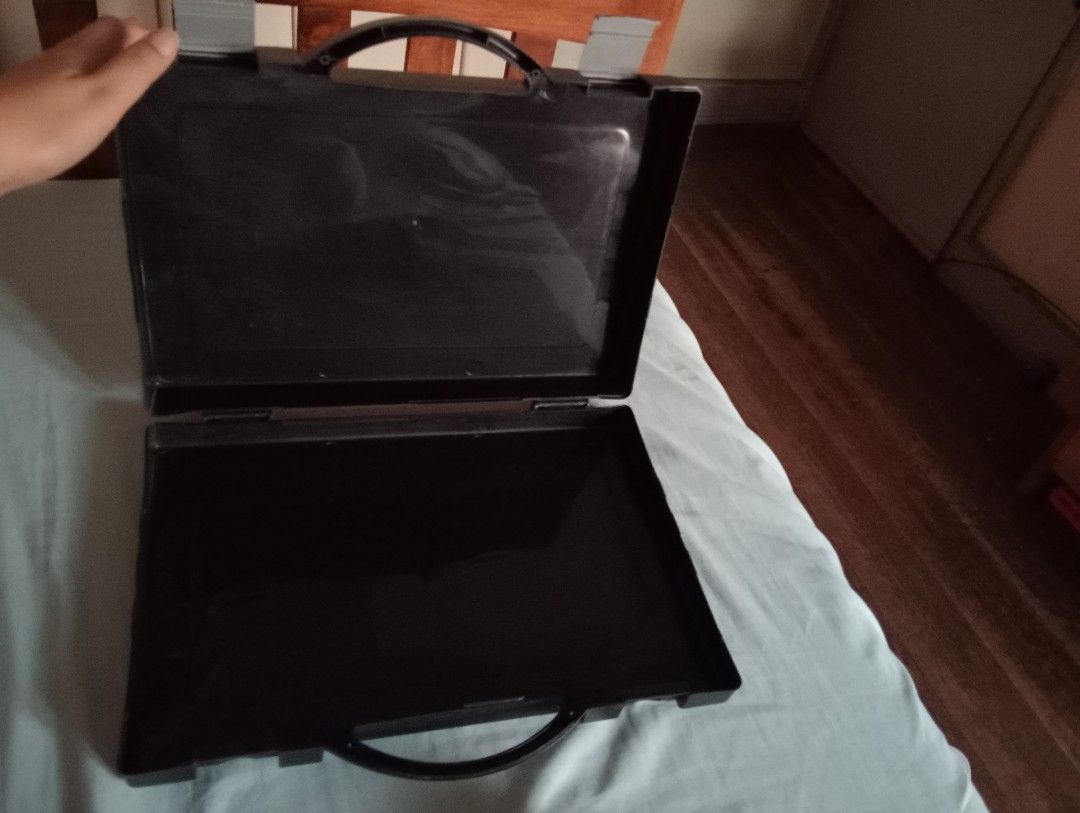 Black plastic storage case with handle and latches (Category: Storage Boxes & Baskets) located in Makati City. Submitted by YSL80022 (Listing ID 1471145283, Image 3). Description: - Durable black plastic utility case - Sturdy top carrying handle - Secure dual grey plastic locking clips - Spacious empty interior for tools, small items, or documents - Lightweight and portable - Condition: Minor scuffs from normal handling - Size: can fit long bond 