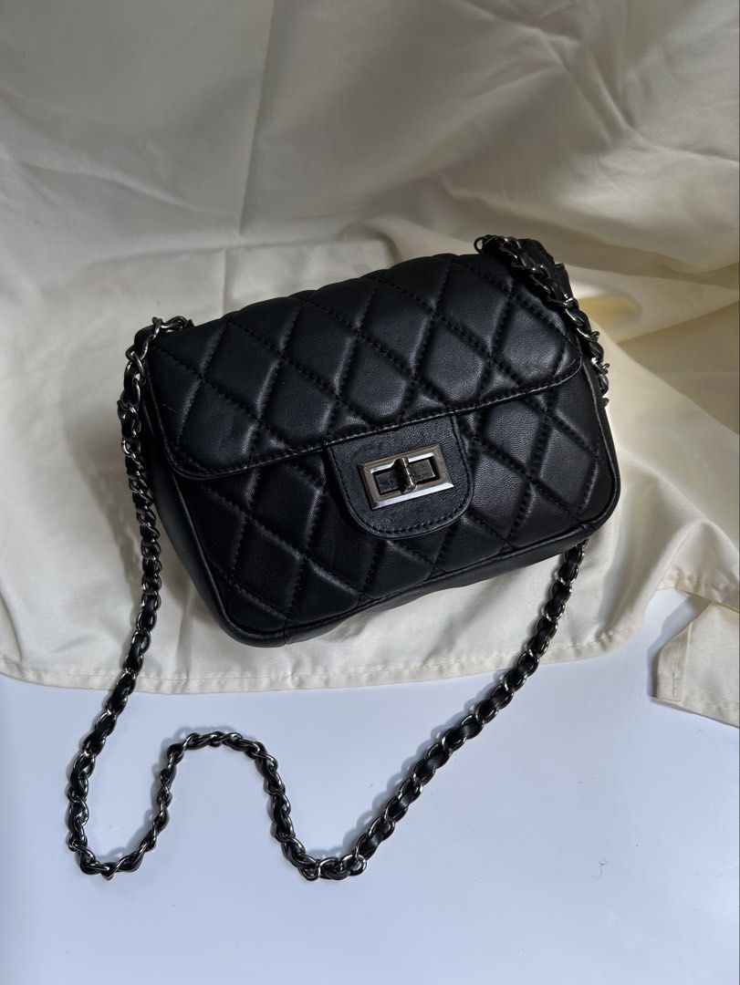 Black Quilted Shoulder Bag with Chain Strap (Category: Shoulder Bags) located in Cagayan de Oro. Submitted by elviecup (Listing ID 1471194276, Image 1). Description: - Style: Classic black quilted shoulder bag with diamond pattern - Hardware: Silver-tone metal twist lock on front flap - Strap: Dark metallic chain threaded with black material - Size: Compact, perfect for daily essentials - Quality: Clean stitching throughout for a polished look - 