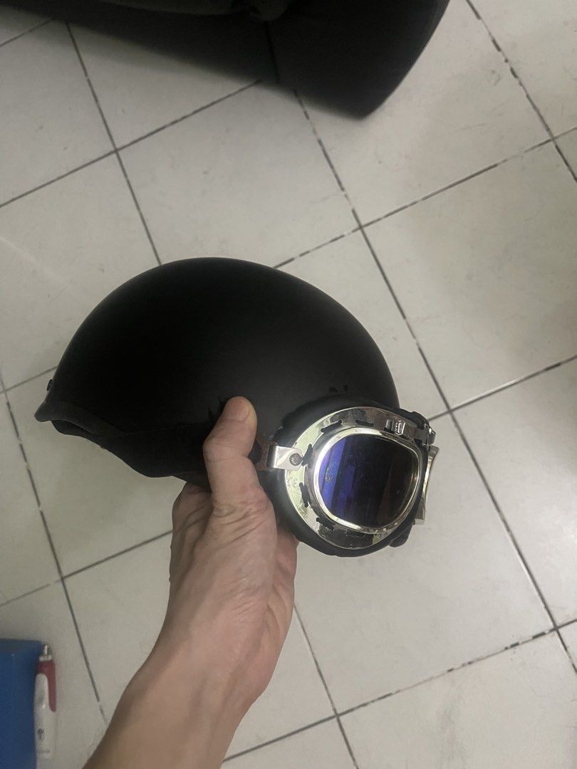 Black vintage motorcycle half helmet with goggles (Category: Bicycles) located in Manila. Submitted by pasaybestfinds (Listing ID 1471246024, Image 2). Description: - Includes detachable chrome aviator goggles with blue reflective lenses - Secure adjustable chin strap with red quick-release buckle - Comfortable padded interior lining with built-in adjustable fit mechanism - Minimal wear on shell and hardware.