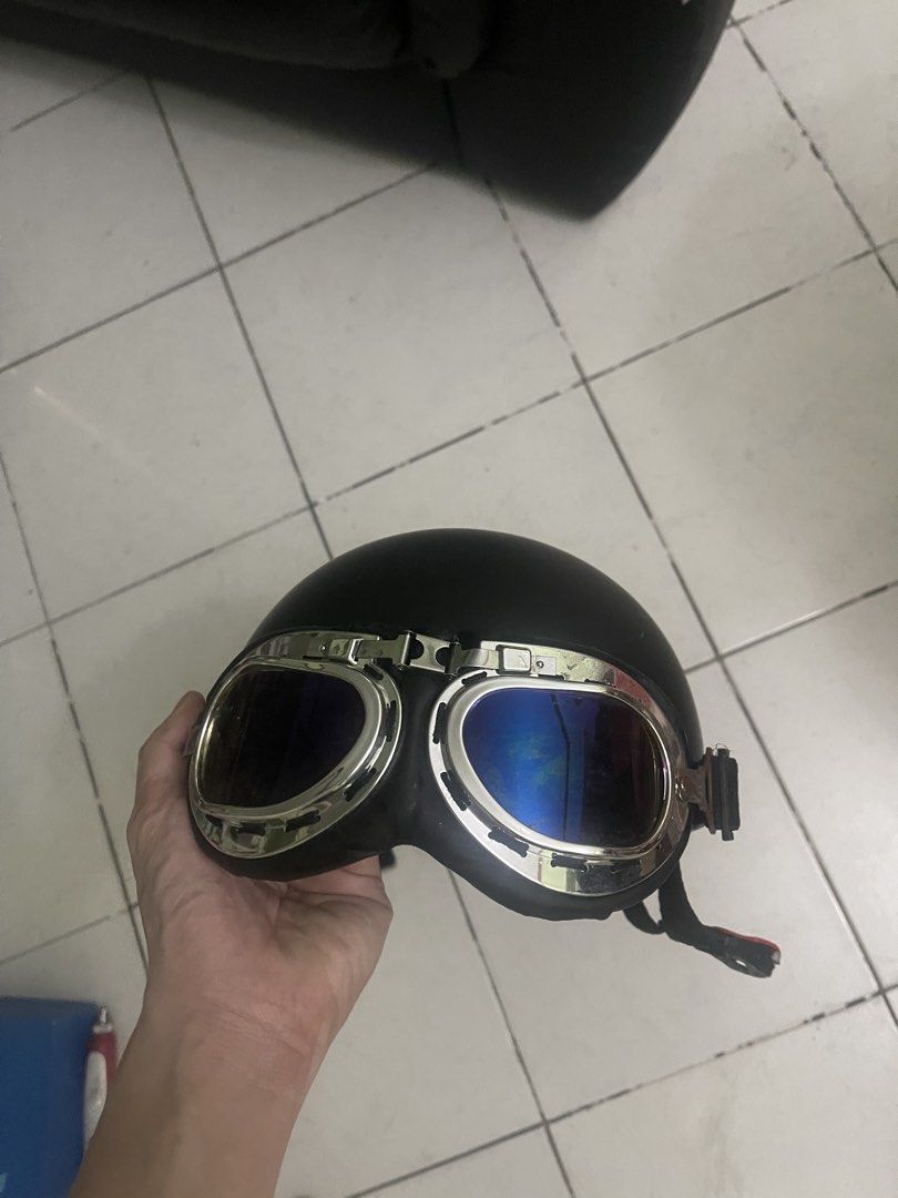 Black vintage motorcycle half helmet with goggles (Category: Bicycles) located in Manila. Submitted by pasaybestfinds (Listing ID 1471246024, Image 1). Description: - Includes detachable chrome aviator goggles with blue reflective lenses - Secure adjustable chin strap with red quick-release buckle - Comfortable padded interior lining with built-in adjustable fit mechanism - Minimal wear on shell and hardware.