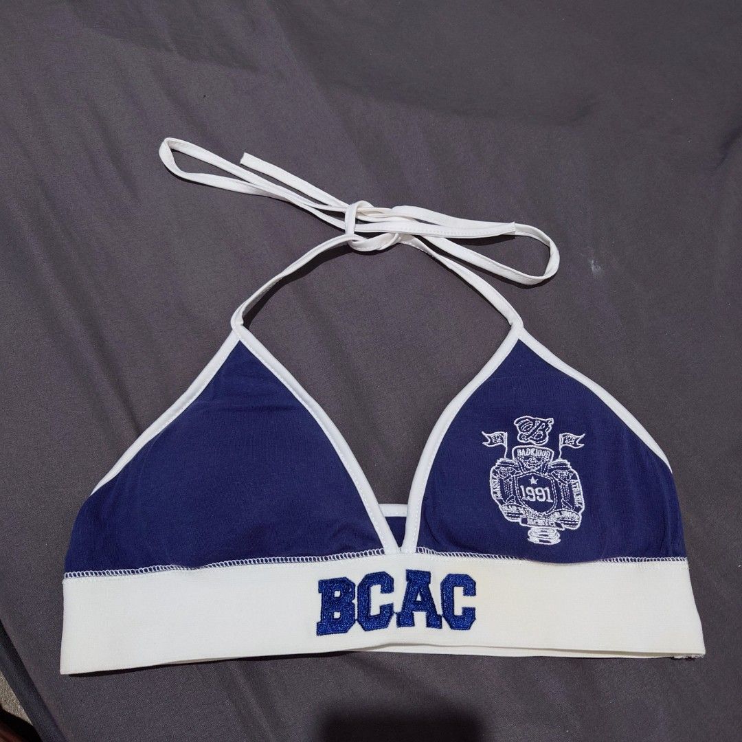 Blue and White Halter Top with BCAC Print (Category: Sleeveless) located in Diffun. Submitted by declutteredbyJill (Listing ID 1471233890, Image 1). Description: - Navy blue and white halter top with adjustable neck ties - Thick elastic underbust band featuring bold 'BCAC' lettering - Detailed white collegiate crest emblem with '1991' on the right cup - Stylish white trim framing the triangle cups - Made from a comfortable, soft cotton-blend fabr