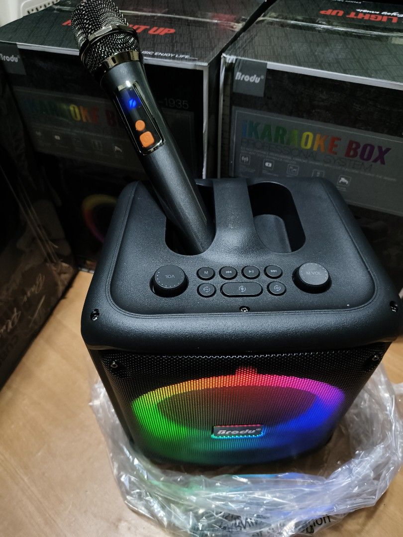 Brodu BTS-1935 iKaraoke Box Professional System (Category: Soundbars, Speakers & Amplifiers) located in Manila. Submitted by reascheyss51406 (Listing ID 1471120119, Image 2). Description: - Model: Brodu BTS-1935 Portable Karaoke Speaker - Color/Design: Black cube shape with vibrant front RGB colorful ring light - Includes: 1 wireless microphone with digital display and orange control buttons - Controls: Top panel with master volume knobs, track n