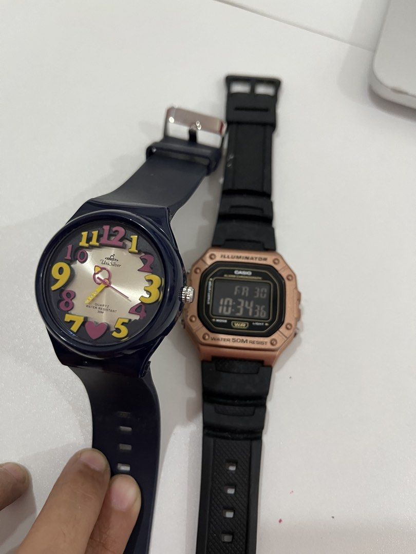 Casio Illuminator and UniSilver Quartz Watch Bundle (Category: Women's Watches) located in Rizal. Submitted by oncelove143 (Listing ID 1471138976, Image 1). Description: - Watch 1: Casio Illuminator digital watch, trendy rose gold case with a durable black strap, and 50m water resistance. - Watch 2: Dark blue UniSilver analog watch featuring fun, colorful numbers and a charming heart marker at the bottom. - Both watches come with straps already a