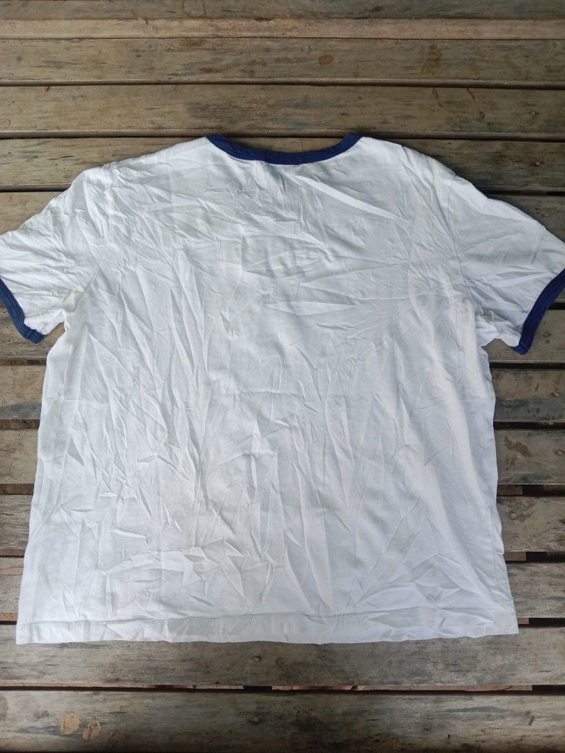 Celine Paris White Ringer T-Shirt Size M (Category: Shirts) located in Manila. Submitted by nadyrl (Listing ID 1471243140, Image 2). Description: - Brand: Celine Paris - Design: White ringer tee with blue trim on collar and sleeves - Graphic: Large black Celine logo and Triomphe graphic on chest - Material: 100% cotton, Made in Italy - Size: Medium (M) - Fit: Regular fit, classic casual everyday wear.