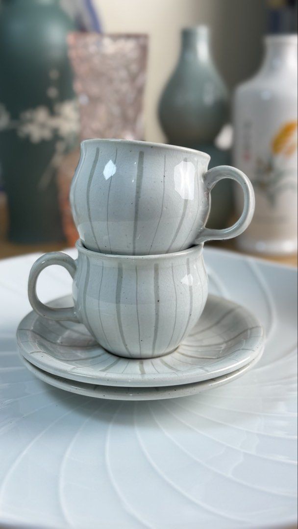 Ceramic Tea Cup and Saucer Set with Striped Pattern (Category: Coffee & Tea Tableware) located in Masinloc. Submitted by kristineba02273 (Listing ID 1471146019, Image 3). Description: - Handmade ceramic tea cups with matching saucers (Set of 2) - Light grey glaze featuring darker vertical stripes and a unique crackle effect - Minimalist Japanese/Korean pottery aesthetic that fits any neutral table setting - Practical stackable design for easy and