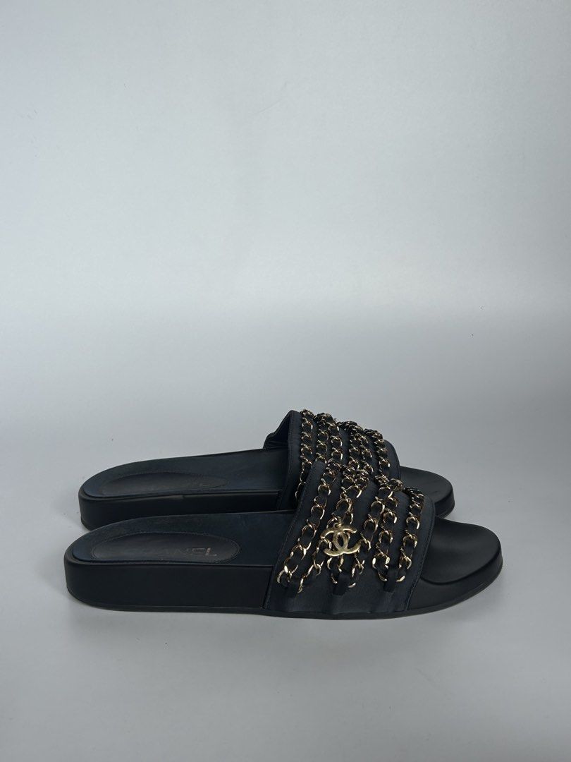 Chanel Black Leather Chain Slides Sandals (Category: Sneakers & Footwear) located in Tacloban City. Submitted by houseofluxury.co (Listing ID 1471191925, Image 2). Description: Chanel black leather slides. Interwoven chain detail across the wide strap with CC logo charm. Smooth footbed with gold Chanel logo stamp. Thick black soles with traction pattern underneath, stamped Made in Italy. Slip-on design, comfortable daily wear. Minimal wear on bot