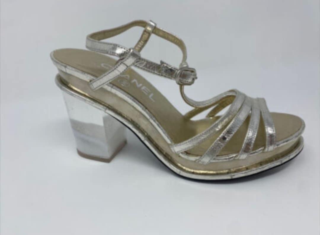 Chanel Metallic Silver Strappy Platform Block Heel Sandals (Category: Sneakers & Footwear) located in Paranaque City. Submitted by calm_youngstore7 (Listing ID 1471170749, Image 1). Description: - Authentic Chanel silver metallic leather strappy sandals - Chic T-strap design with adjustable ankle buckle and multi-strap toe construction - Modern clear chunky block heels and platform soles for added comfort - Features the iconic Chanel logo stamp o