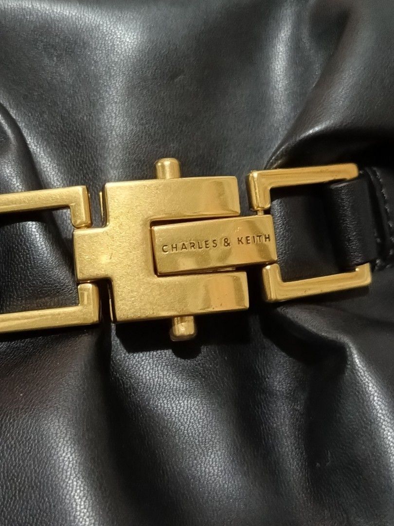 Charles & Keith Black Bucket Bag (Category: Shoulder Bags) located in Lucena. Submitted by jeankristi73450 (Listing ID 1471272810, Image 2). Description: - Brand: Charles & Keith - Style: Black bucket bag with gold-tone front hardware - Material: Polyurethane outer with cotton inner lining - Features: Adjustable shoulder strap, interior zip pocket, and clean bottom base - Condition: Brand new with tag still attached.