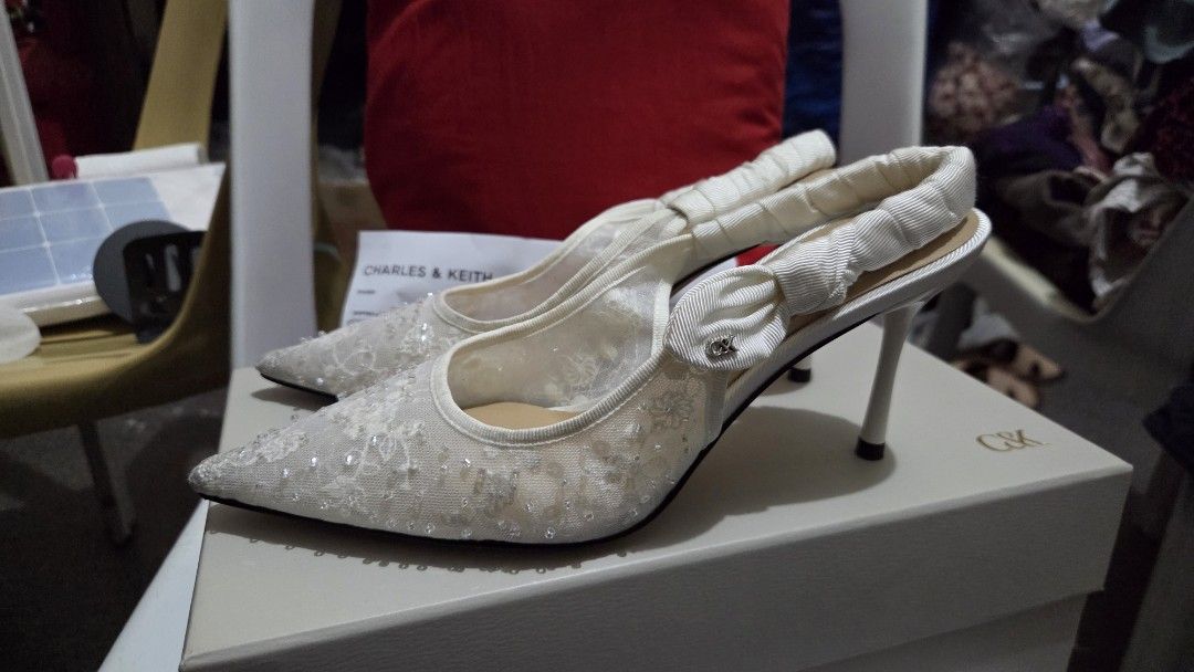 Charles & Keith White Beaded Lace Slingback Heels (Category: Heels) located in Manila. Submitted by lealee12 (Listing ID 1471269038, Image 3). Description: - Brand: Charles & Keith - Color: white - Style: Pointed toe stiletto high heels with slingback strap - Details: Lace mesh fabric covered in tiny beads and sequins, ruched ribbon detail, and metal C&K logo charm - Condition: Includes original box & receipt, worn once - Perfect for formal event