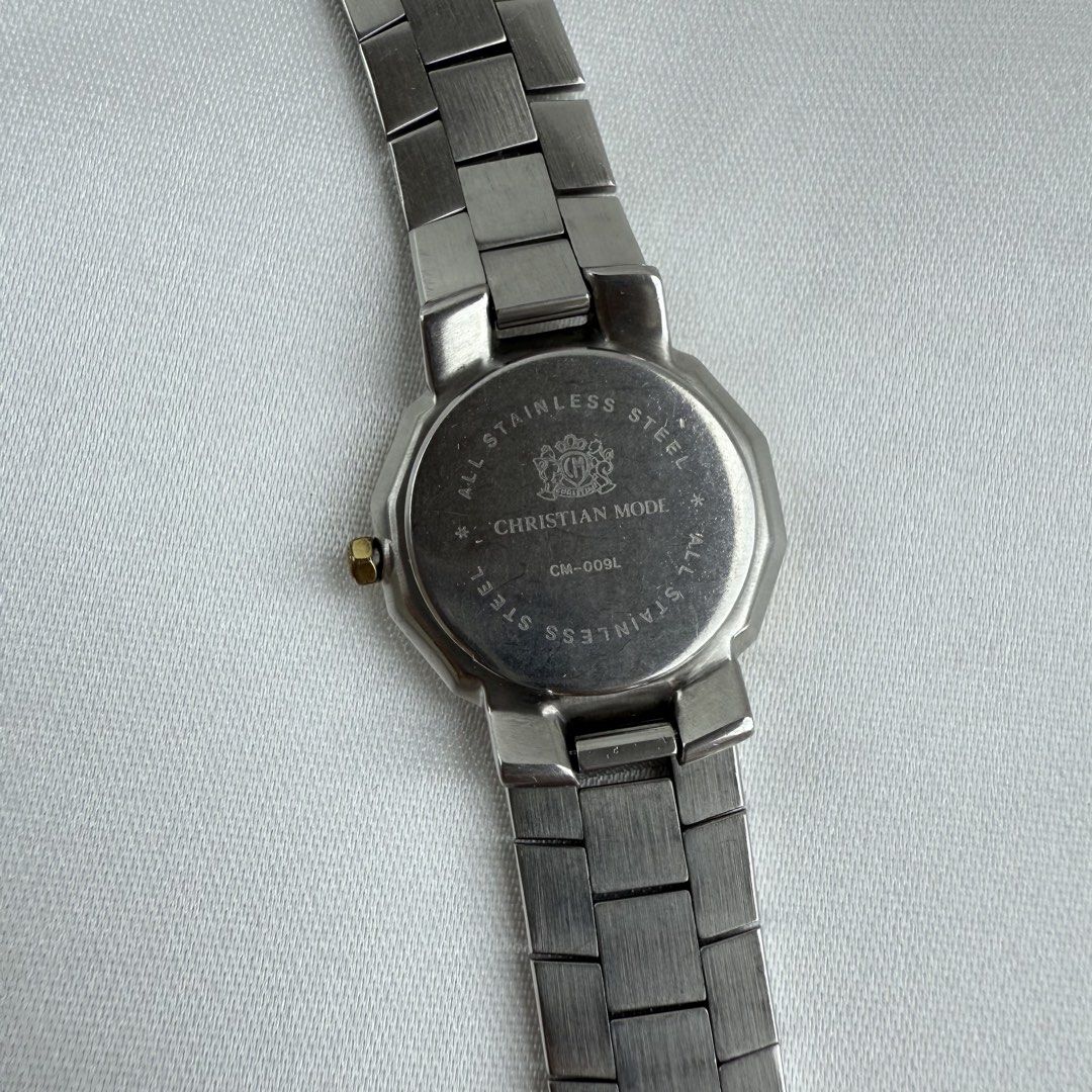 Christian Mode CM-009L Two-Tone Quartz Watch (Category: Women's Watches) located in Cagayan de Oro. Submitted by sbabs1996 (Listing ID 1471255897, Image 3). Description: - Brand: Christian Mode - Model: CM-009L (stamped on caseback) - Movement: Battery-operated quartz analog - Strap: Two-tone silver and gold stainless steel bracelet - Dial: Clean white dial with classic Roman numerals - Features: Date window at the 6 o'clock position - Design: El