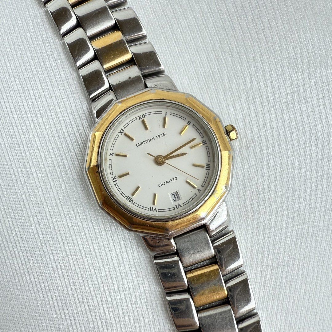 Christian Mode CM-009L Two-Tone Quartz Watch (Category: Women's Watches) located in Cagayan de Oro. Submitted by sbabs1996 (Listing ID 1471255897, Image 2). Description: - Brand: Christian Mode - Model: CM-009L (stamped on caseback) - Movement: Battery-operated quartz analog - Strap: Two-tone silver and gold stainless steel bracelet - Dial: Clean white dial with classic Roman numerals - Features: Date window at the 6 o'clock position - Design: El