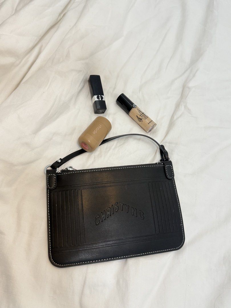 Christy Ng Black Leather Pouch Bag (Category: Luxury Bags & Wallets) located in Manila. Submitted by k.e9999 (Listing ID 1471262068, Image 2). Description: - Brand: Christy Ng - Material: Premium black leather with clean interior lining - Design: Contrast white stitching, vertical pleat details on both sides, and debossed front logo - Closure: Secure zip top - Strap: Short shoulder strap with durable metal hardware - Capacity: Compact size, perfe